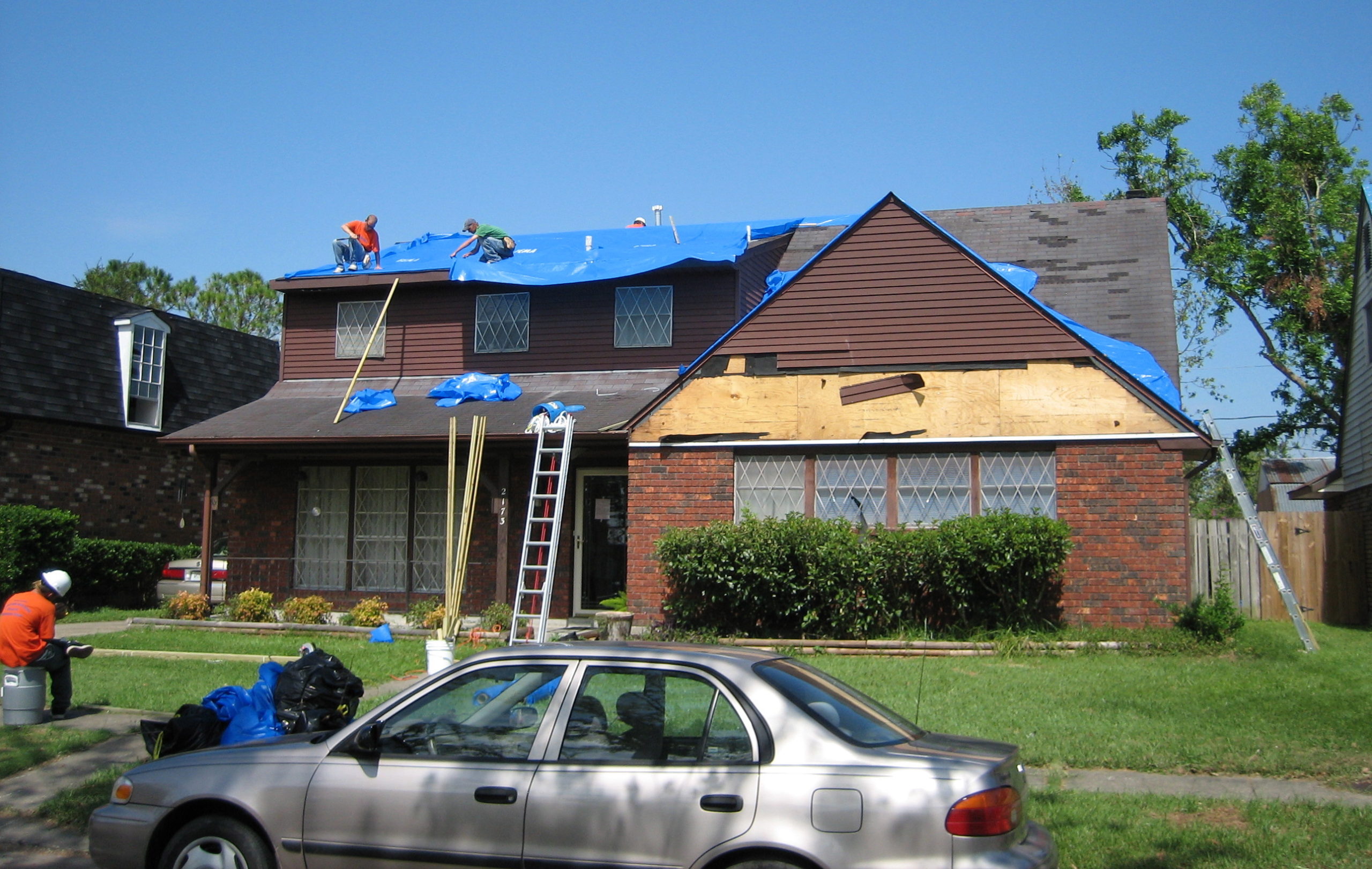 People Installing a Roof Tarp